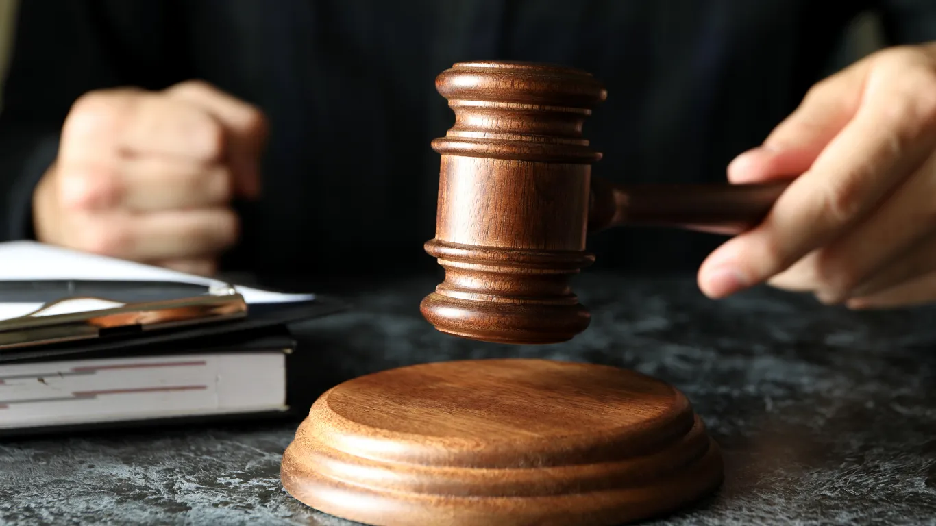 Drevené sudcovské kladivko a spis pri vyhľadávaní exekučných dražieb nehnuteľností